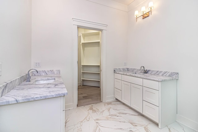 1615 N Garland Ave, Fayetteville, AR 72703 - bathroom with vanity, marble finish floors, baseboards, and a walk in closet