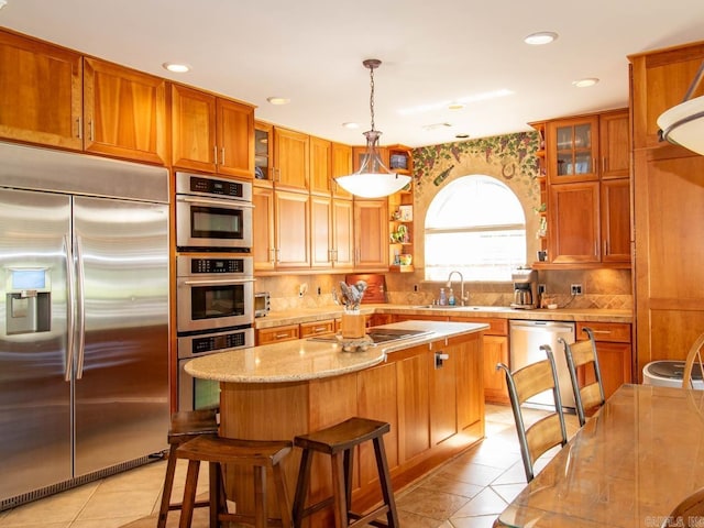 1 Witness Tree Ln, Paron, AR 72122 - kitchen featuring stainless steel appliances, a sink, light tile patterned floors, brown cabinetry, and recessed lighting