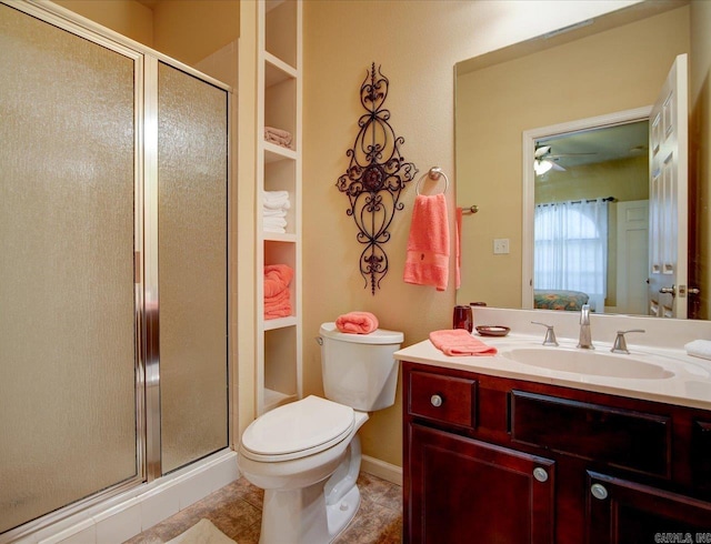 full bathroom with a stall shower, vanity, toilet, ceiling fan, and baseboards