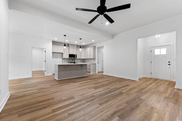 81 Lewis Loop, Greenbrier, AR 72058 - unfurnished living room featuring baseboards, light wood-type flooring, a ceiling fan, recessed lighting, and a sink
