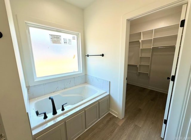 81 Lewis Loop, Greenbrier, AR 72058 - bathroom featuring a garden tub, wood finished floors, and a walk in closet