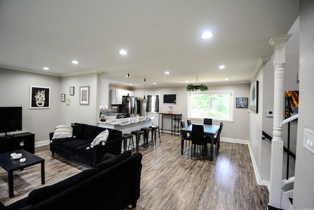 living room with crown molding, wood finished floors, recessed lighting, and baseboards