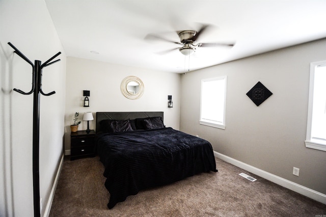 bedroom with dark colored carpet, baseboards, and a ceiling fan