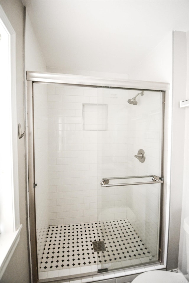full bath featuring a stall shower and toilet