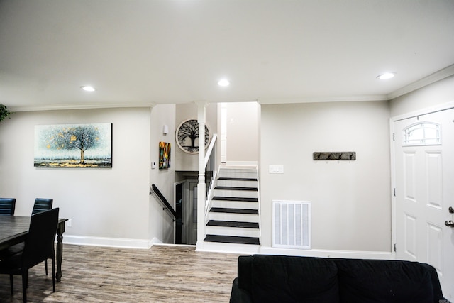 entrance foyer with wood finished floors, baseboards, recessed lighting, ornamental molding, and stairs