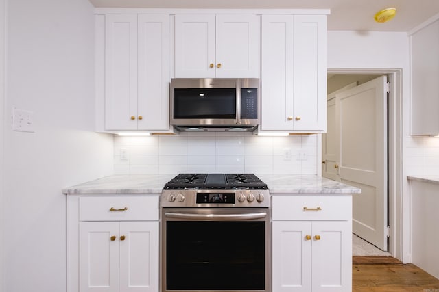 700 N Taylor St, Little Rock, AR 72205 - kitchen with stainless steel appliances, white cabinetry, and light wood-style flooring