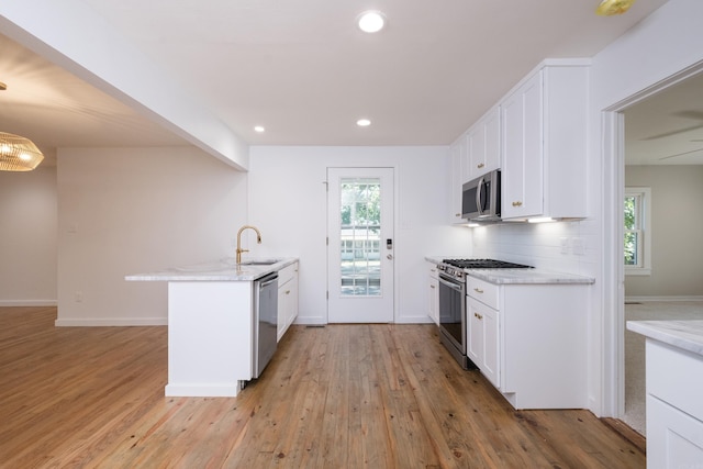 700 N Taylor St, Little Rock, AR 72205 - kitchen with stainless steel appliances, white cabinetry, a peninsula, light wood-style flooring, and plenty of natural light