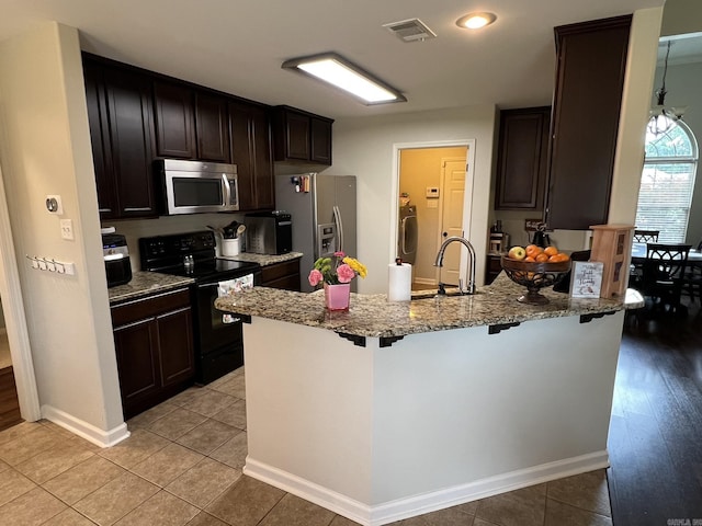 1056 Skyline Dr, Alexander, AR 72002 - kitchen featuring appliances with stainless steel finishes, a sink, a breakfast bar area, a peninsula, and light stone counters