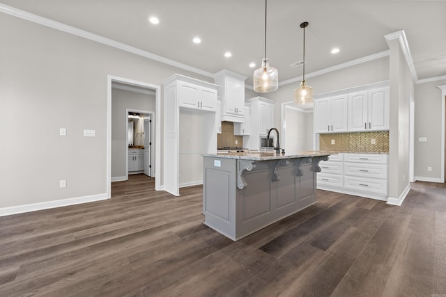 10114 Hidden Cir, Sherwood, AR 72120 - kitchen featuring crown molding, tasteful backsplash, a kitchen breakfast bar, white cabinets, and recessed lighting