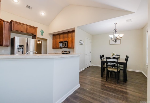 3961 Mountaincrest Cir, Alexander, AR 72002 - kitchen featuring appliances with stainless steel finishes, a chandelier, brown cabinets, dark wood-type flooring, and baseboards