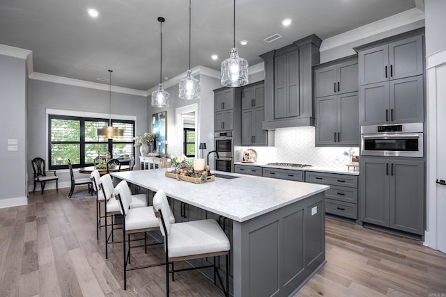 11 Haywood Ct, Little Rock, AR 72223 - kitchen featuring ornamental molding, gray cabinets, a spacious island, tasteful backsplash, and appliances with stainless steel finishes