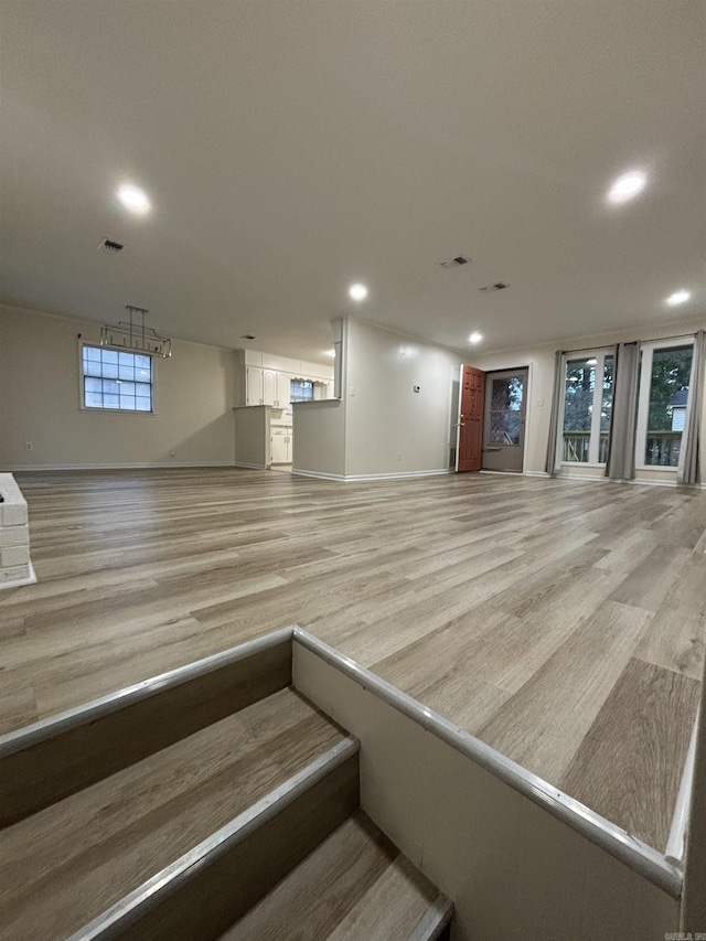 stairway with wood finished floors, baseboards, and recessed lighting