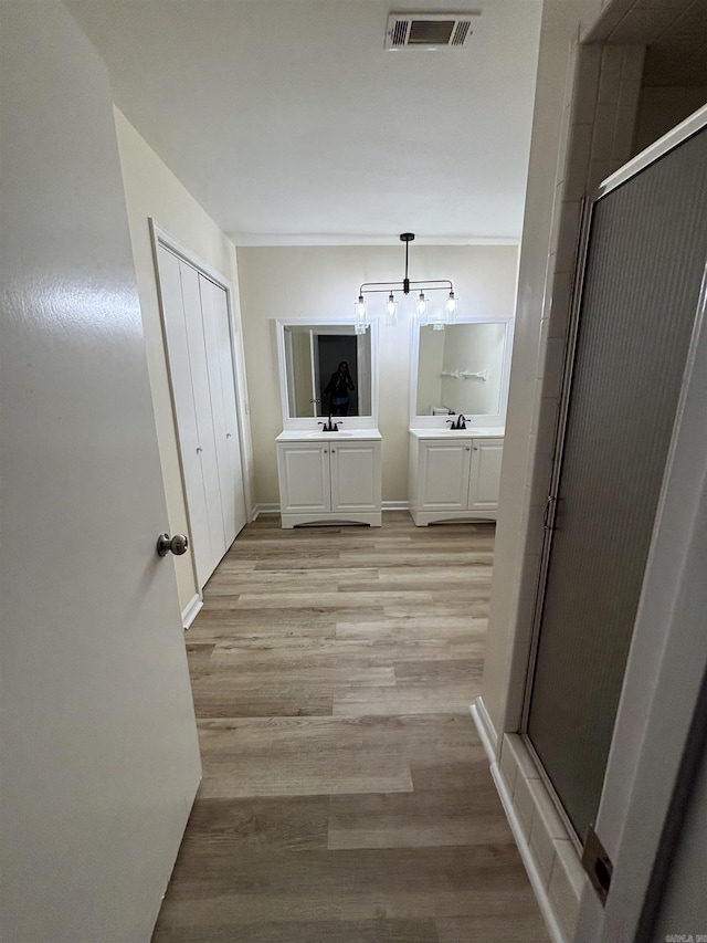 full bathroom with wood finished floors, a stall shower, and vanity