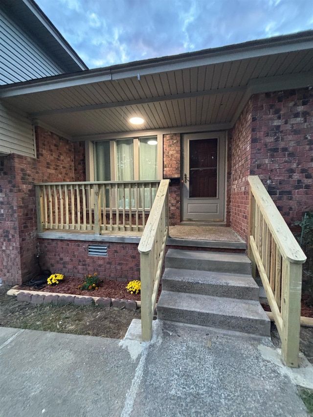 entrance to property with brick siding and covered porch