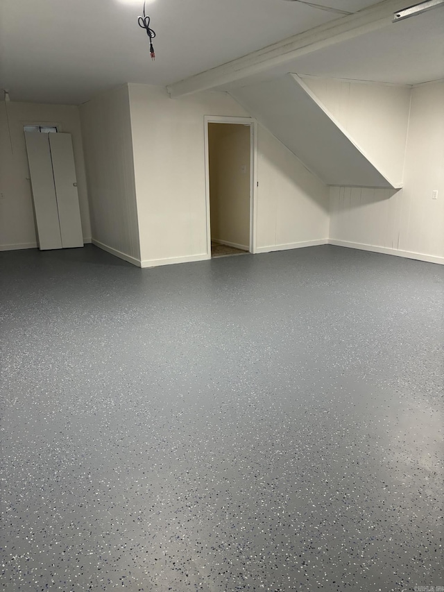 bonus room featuring speckled floor and baseboards
