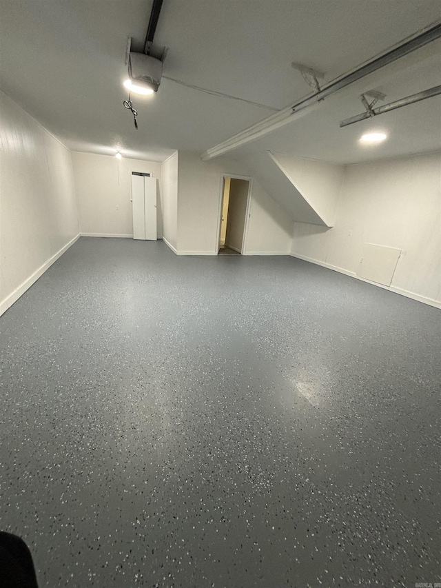 garage featuring a garage door opener and baseboards