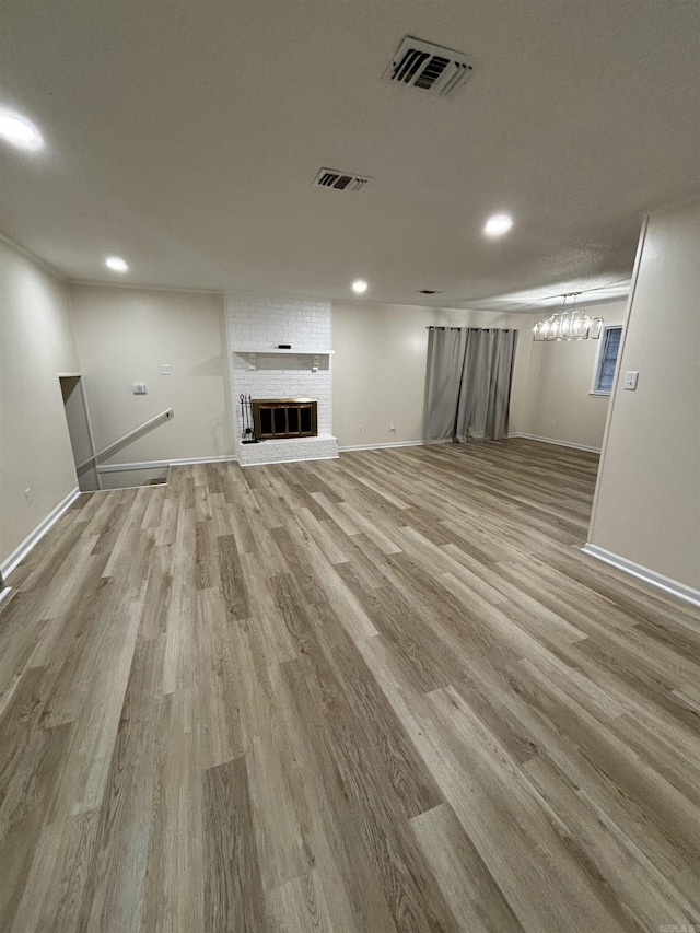 unfurnished living room with light wood-style flooring, recessed lighting, baseboards, and a fireplace