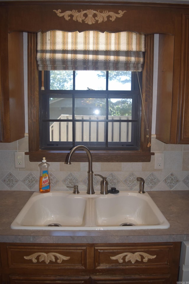 206 Beaconsfield Rd, Sherwood, AR 72120 - kitchen view of a sink, backsplash, and brown cabinets