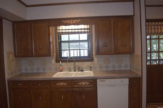 206 Beaconsfield Rd, Sherwood, AR 72120 - kitchen with white dishwasher, a sink, tasteful backsplash, light countertops, and brown cabinets