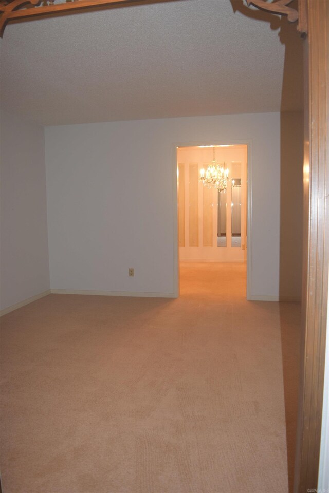 206 Beaconsfield Rd, Sherwood, AR 72120 - spare room featuring a chandelier, carpet floors, and baseboards