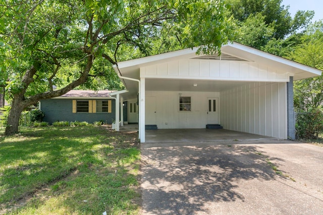 605 N W St, Morrilton, AR 72110 - ranch-style home featuring concrete driveway, a front lawn, an attached carport, and board and batten siding