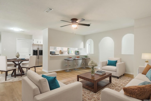 605 N W St, Morrilton, AR 72110 - living area with light wood-style flooring, ceiling fan, baseboards, and arched walkways