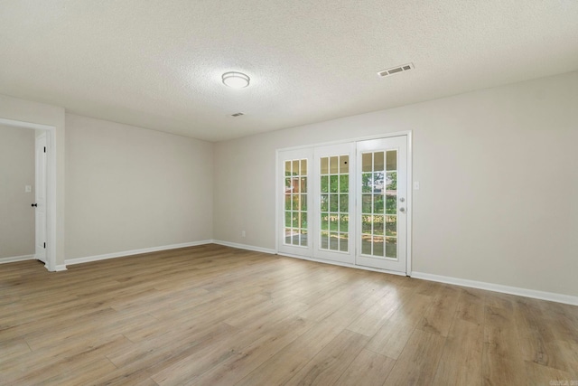 605 N W St, Morrilton, AR 72110 - unfurnished room with a textured ceiling, light wood-type flooring, and baseboards