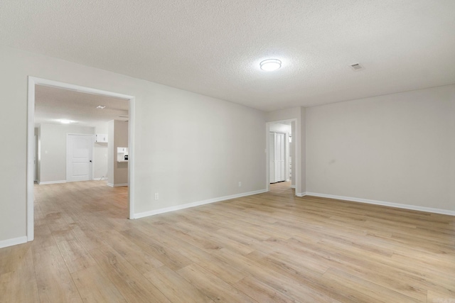 605 N W St, Morrilton, AR 72110 - unfurnished room featuring light wood-type flooring, baseboards, and a textured ceiling