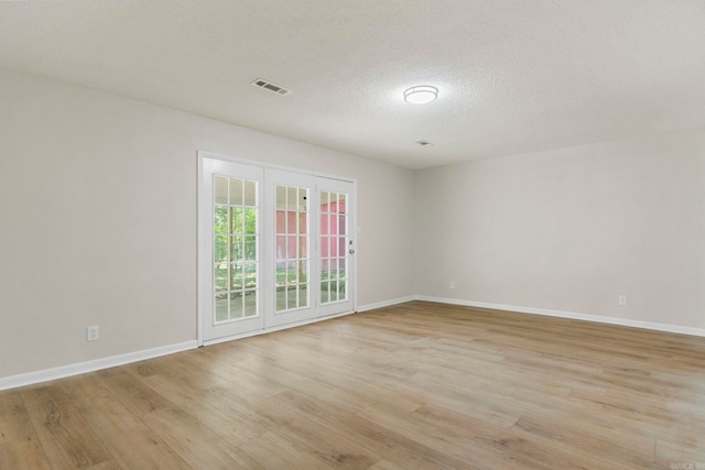 605 N W St, Morrilton, AR 72110 - empty room with light wood-type flooring, baseboards, and a textured ceiling