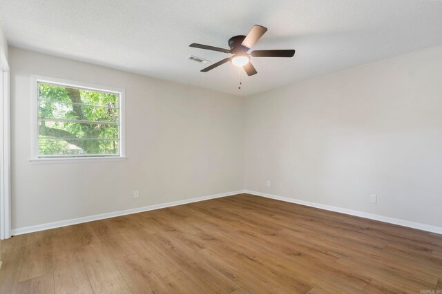 605 N W St, Morrilton, AR 72110 - empty room featuring wood finished floors, a ceiling fan, and baseboards