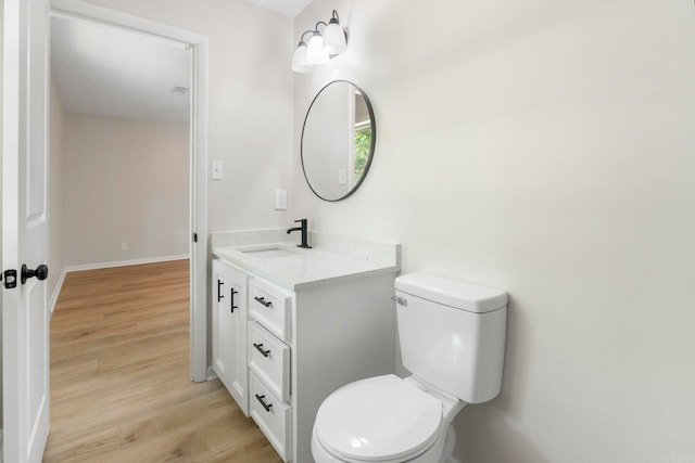 605 N W St, Morrilton, AR 72110 - bathroom featuring vanity, toilet, wood finished floors, and baseboards