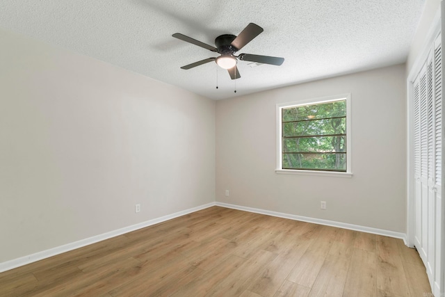 605 N W St, Morrilton, AR 72110 - unfurnished bedroom with light wood finished floors, a closet, a textured ceiling, baseboards, and ceiling fan