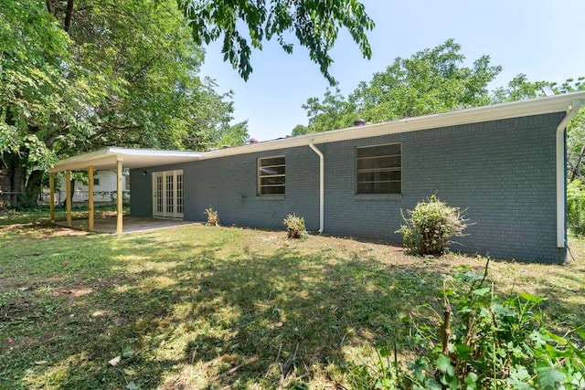 605 N W St, Morrilton, AR 72110 - view of front of home featuring french doors, brick siding, a front yard, and a patio area