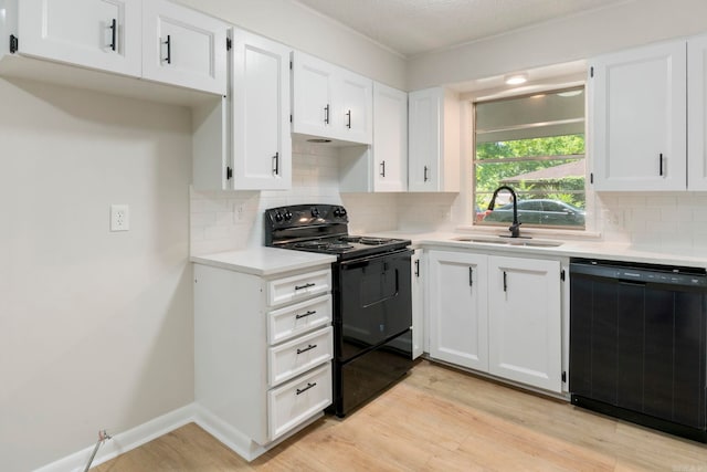 605 N W St, Morrilton, AR 72110 - kitchen with black appliances, a sink, light countertops, and white cabinets
