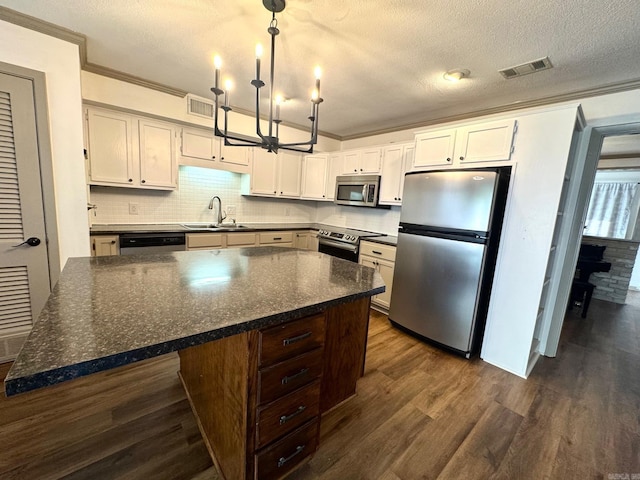 28 Timothy Ln, Conway, AR 72034 - kitchen featuring stainless steel appliances, a sink, crown molding, dark wood-style flooring, and a textured ceiling
