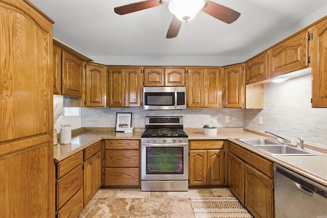 10626 Pineview Dr, Mabelvale, AR 72103 - kitchen featuring stainless steel appliances, a sink, brown cabinetry, decorative backsplash, and light countertops