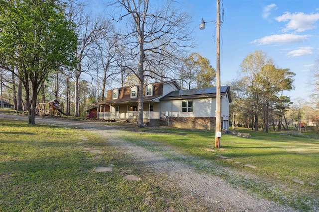10626 Pineview Dr, Mabelvale, AR 72103 - view of front of home with covered porch, roof mounted solar panels, a front yard, and dirt driveway