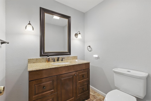 10626 Pineview Dr, Mabelvale, AR 72103 - half bathroom with toilet, vanity, stone finish floors, and baseboards