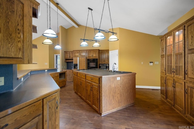 36 Brentwood Cv, Cabot, AR 72023 - kitchen featuring black oven, stainless steel microwave, a kitchen island with sink, paneled refrigerator, and brown cabinetry