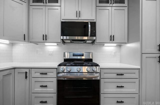 2311 S Louisiana St, Little Rock, AR 72206 - kitchen with appliances with stainless steel finishes, light countertops, glass insert cabinets, and backsplash