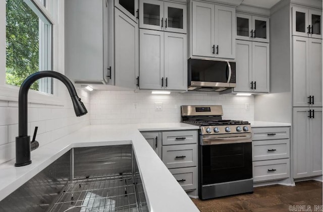 2311 S Louisiana St, Little Rock, AR 72206 - kitchen with appliances with stainless steel finishes, a sink, light countertops, and backsplash