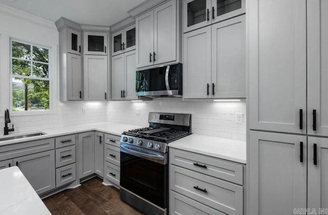 2311 S Louisiana St, Little Rock, AR 72206 - kitchen featuring stainless steel appliances, a sink, light countertops, decorative backsplash, and ornamental molding