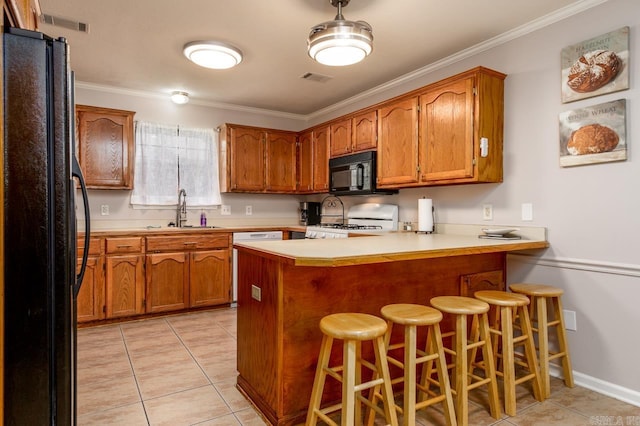 2130 Maplewood Dr, Conway, AR 73034 - kitchen with black appliances, a sink, a peninsula, brown cabinetry, and light tile patterned floors