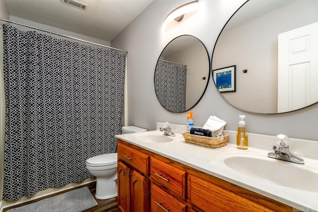2130 Maplewood Dr, Conway, AR 73034 - bathroom with double vanity, toilet, wood finished floors, and curtained shower