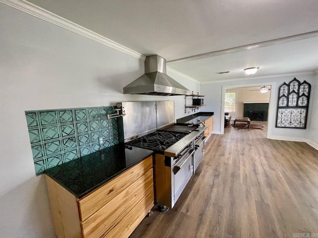 3804 Ridge Rd, North Little Rock, AR 72116 - kitchen featuring wall chimney range hood, dark wood-type flooring, crown molding, range with gas stovetop, and dark countertops