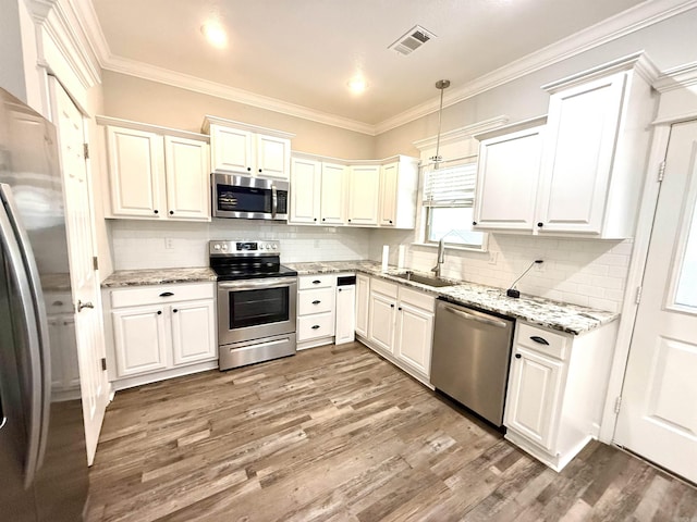 604 Samuel Loyce Dr, Searcy, AR 72143 - kitchen featuring stainless steel appliances, a sink, light wood-style floors, ornamental molding, and tasteful backsplash