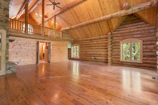 10836 Bray Rd, Elkins, AR 72727 - unfurnished living room with high vaulted ceiling, wood ceiling with exposed beams, plenty of natural light, wood-type flooring, and rustic walls