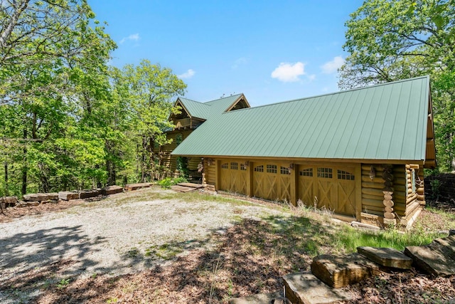 10836 Bray Rd, Elkins, AR 72727 - view of side of home with log exterior, a garage, and metal roof