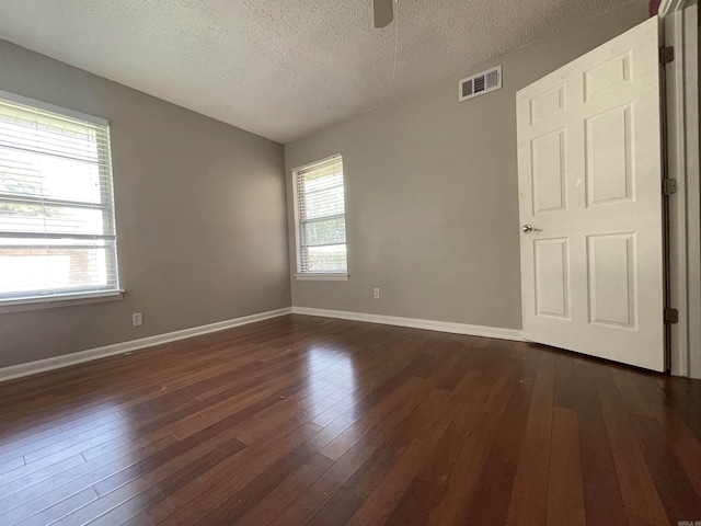 101 Chula Vista Rd, El Dorado Springs, AR 71730 - unfurnished room featuring a textured ceiling, plenty of natural light, dark wood-type flooring, a ceiling fan, and baseboards