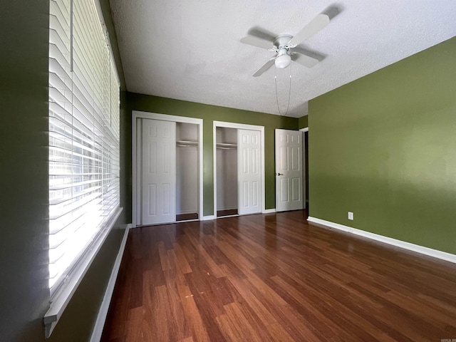 101 Chula Vista Rd, El Dorado Springs, AR 71730 - unfurnished bedroom featuring multiple closets, wood finished floors, baseboards, ceiling fan, and a textured ceiling